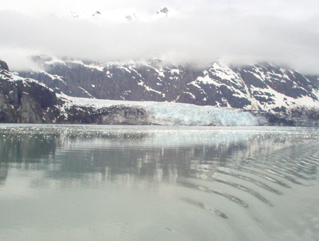 The Margerie Glacier with mountain peaks above the clouds