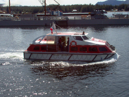 A tender with a full load sails past a pier construction site.  Apparently there's a need for more mooring space.